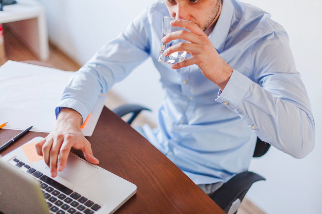 Professional office worker enjoying clean filtered water during productive workday