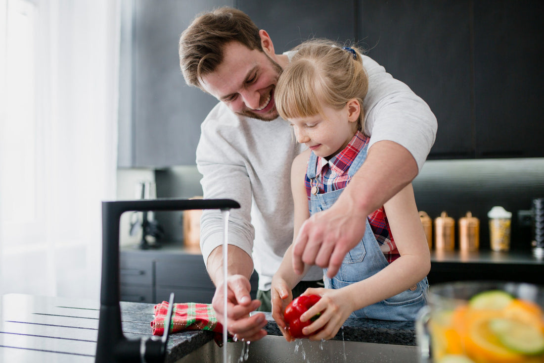 Father and daugther enjoying pure filtered water in modern kitchen with home water filtration system