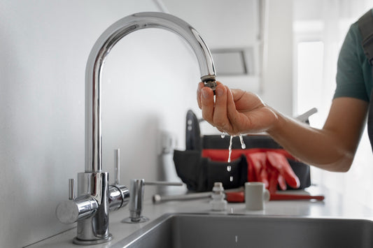 Homeowner examining hard water scales on faucet and fixtures showing mineral buildup damage