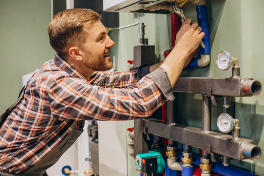Homeowner performing DIY whole house water filter replacement in modern utility room setup
