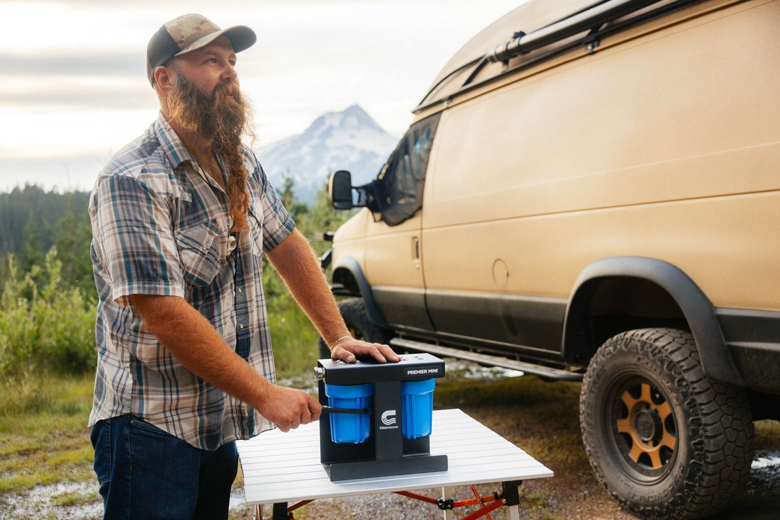 RV traveler replacing water filter housing at scenic mountain campground with portable tools and clean water supply