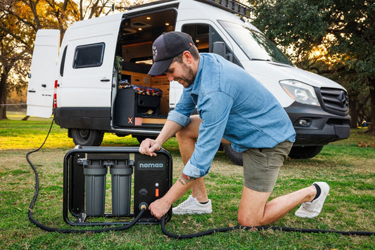 Rugged Nomad portable reverse osmosis system for RV, installed outdoors at campsite.