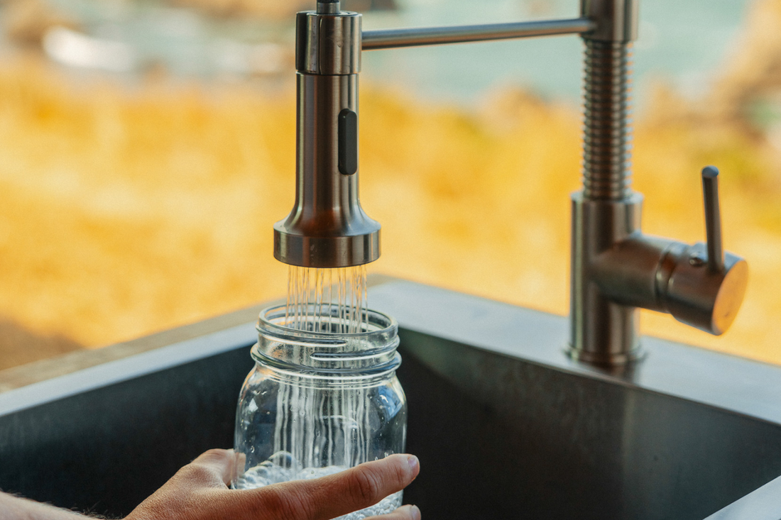 Clean filtered water pouring from kitchen faucet showcasing caravan home water filtration system benefits