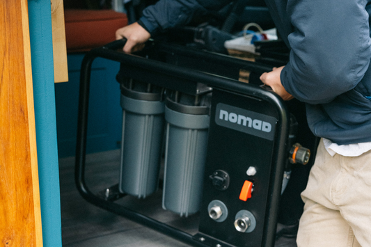 Professional testing off-grid water filtration system quality with portable equipment in remote wilderness location