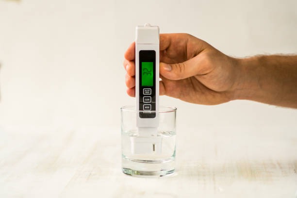 Homeowner testing water hardness at home using professional testing kit on kitchen counter