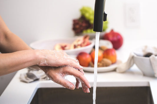 Hands washing under clean water representing daily hygiene routines