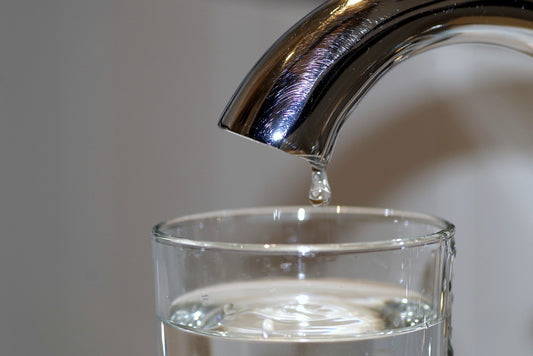 Tap water pouring into a glass.