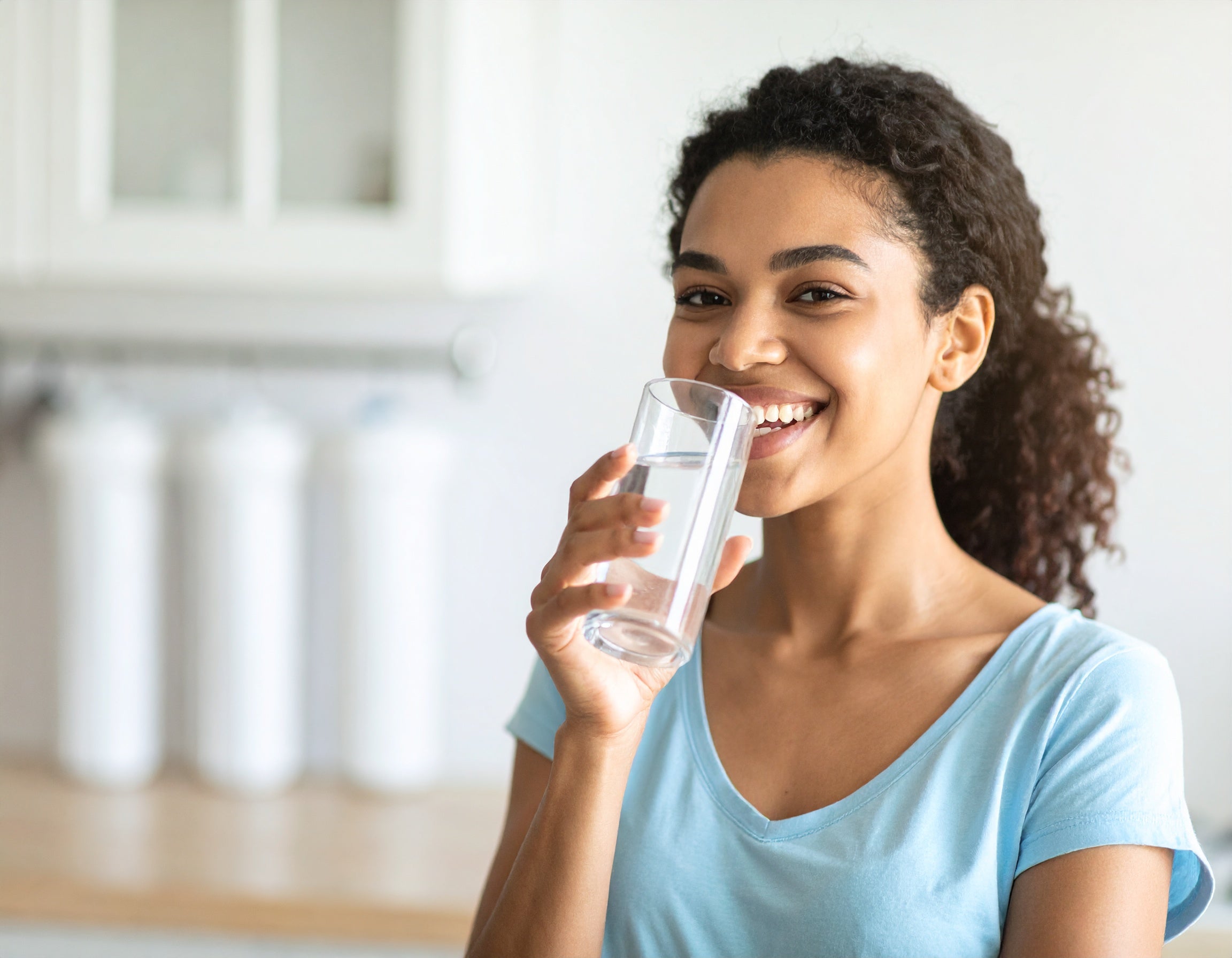 Water filters direct - woman with crystal quest countertop water filter and home water filtration system benefits