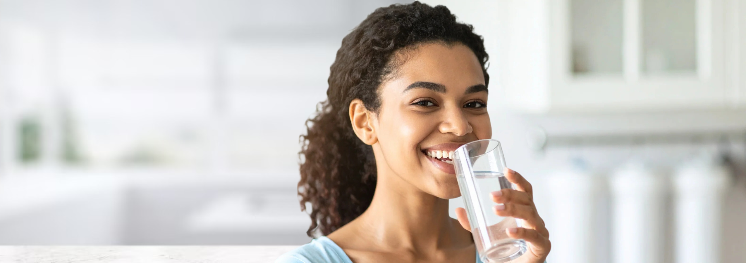 Water filters direct - woman with crystal quest countertop water filter and home water filtration system benefits